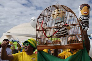 Demonstrators carry a cage holding a doll of Brazil's former President Luiz Inacio Lula da Silva in prison garb, during a protest demanding the impeachment of Brazil's current President Dilma Rousseff in Brasilia, Brazil, Sunday, March 13, 2016. The corruption scandal at the state-run oil giant Petrobras has ensnared key figures from Rousseff’s Workers’ Party, including her predecessor and mentor, Lula da Silva, as well as members of opposition parties.