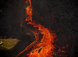 Lava from the Kilauea volcano erupts from a fissure and forms a river of lava flowing down to Kapoho on Sunday, June 10, 2018, in Pahoa, Hawaii.