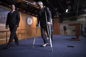 Rep. Roger Williams, R-Texas, who injured his ankle during a shooting at a congressional baseball game, leaves a news conference on crutches, assisted by his aide J. Spencer Freebairn, left, at the Capitol in Washington, Wednesday, June 14, 2017.