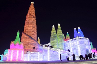 Visitors walk among the attractions at the Harbin International Ice and Snow Sculpture Festival in Harbin in ...