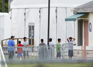 Immigrant children walk in a line outside the Homestead Temporary Shelter for Unaccompanied Children, a former Job Corps site that now houses them, on Wednesday, June 20, 2018, in Homestead, Fla.