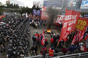 Police stand guard where striking protesters block a road the leads to the city from the south, in Buenos Aires, Argentina, Monday, June 25, 2018.