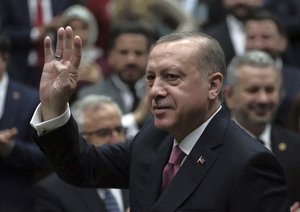 Turkey's President Recep Tayyip Erdogan waves as he arrives to address members of his ruling party at the parliament in Ankara, Turkey, Tuesday, Feb. 20, 2018.