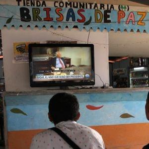 Three former guerrillas watch the election results from La Tienda, the social space in the Icononzo reintegration zone.