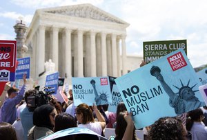 Protesters hold up signs and call out against the Supreme Court ruling upholding President Donald Trump's travel ban outside the the Supreme Court on Capitol Hill in in Washington, Tuesday, June 26, 2018.