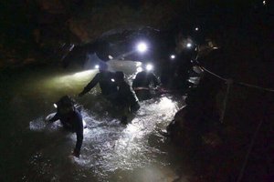 In this handout photo released by Tham Luang Rescue Operation Center, Thai rescue teams walk inside cave complex where 12 boys and their soccer coach went missing, in Mae Sai, Chiang Rai province, in northern Thailand, Monday, July 2, 2018.