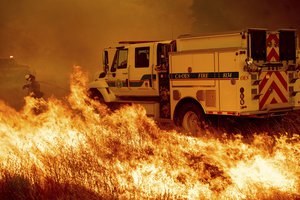 A firefighter scrambles to stop the Pawnee fire as it spots across Highway 20 near Clearlake Oaks, Calif., on Sunday, July 1, 2018.