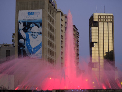 The colored fountain on Plaza Venezuela in front of a giant portrait of President Nicolas Maduro.