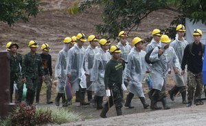 Rescuers walk toward the entrance to a cave complex where five were still trapped, in Mae Sai, Chiang Rai province, northern Thailand Tuesday, July 10, 2018.