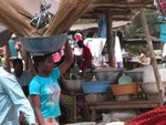 Une fille en train de vendre des balais au marché.  A girl selling brushes at the market. Togo and Africa