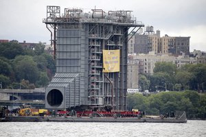 A large generator is moved down the Hudson River as seen from Fort Lee, N.J., Tuesday, Aug. 8, 2017. A 130-foot-(40-meter)-tall steam generator built along the Hudson River outside Albany is on a barge heading south for a New Jersey power plant. (AP Photo/Seth Wenig)