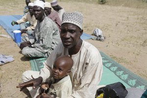 In this Tuesday Dec. 8, 2015 file photo, Mariamu Abubakar, a farmer reacts during an interview with The Associated Press, as he describes that Cameroonian soldiers on Nov. 30 killed about 150 people in his village near Nigeria's Banki border post, stole their livestock and set their huts ablaze, as he sits at Furore camp in Yola, Nigeria.