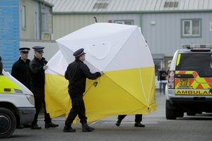 Police officers position a screen outside the vehicle recovery business "Ashley Wood Recovery" in Salisbury, England, Tuesday, March 13, 2018. The use of Russian-developed nerve agent Novichok to poison former-spy Sergei Skripal and his daughter Yulia makes it "highly likely" that Russia was involved, British Prime Minister Theresa May said Monday.