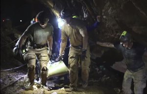 This undated from video released via the Thai NavySEAL Facebook Page on Wednesday, July 11, 2018, shows. Rescuers hold an evacuation boy inside the Tham Luang Nang Non cave in Mae Sai, Chiang Rai province, in northern Thailand. A daring rescue mission in the treacherous confines of a flooded cave in northern Thailand has saved all 12 boys and their soccer coach who were trapped deep within the labyrinth, ending a grueling 18-day ordeal that claimed the life of an experienced volunteer diver and riveted people around the world. (Thai NavySEAL Facebook Page via AP)