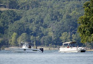 Emergency workers patrol an area Friday, July 20, 2018, near where a duck boat capsized Thursday night resulting in at least 13 deaths on Table Rock Lake in Branson, Mo. Workers were still searching for four people on the boat that were unaccounted for. (AP Photo/Charlie Riedel)