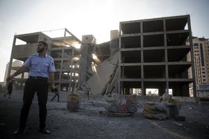 A Palestinian policeman guards next to a destroyed building following an Israeli airstrike in Gaza City , Saturday, July 14, 2018.