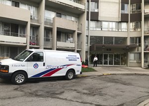 A Toronto Police forensic identification services van sits parked in front of an apartment building in Toronto's Thorncliffe Park, Monday, July 23, 2018. Shooting suspect Faisal Hussain lived in the complex.