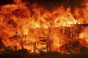 Flames consume a home as the River Fire tears through Lakeport, Calif., on Tuesday, July 31, 2018.