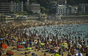 People crowds La Concha beach in the basque city of San Sebastian, northern Spain, Friday, Aug. 3, 2018.