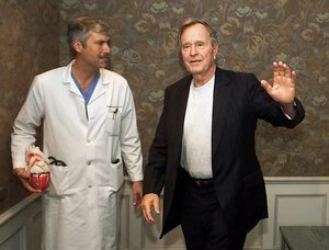 In this Feb. 25, 2000, file photo, former President George H.W. Bush waves as he leaves Methodist Hospital with his cardiologist,Mark Hausknecht, after a news conference in Houston