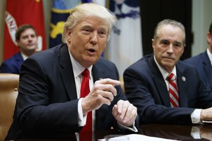 Rep. Chris Collins, R-N.Y. listens at right as President Donald Trump speaks during a meeting with members of Congress in the Roosevelt Room of the White House in Washington, Thursday, Feb. 16, 2017.