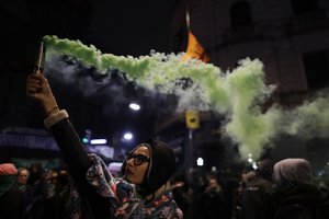 A woman in support of decriminalizing abortion spreads colored smoke outside Congress after lawmakers voted against an abortion bill in Buenos Aires, Argentina, early Thursday, Aug. 9, 2018.