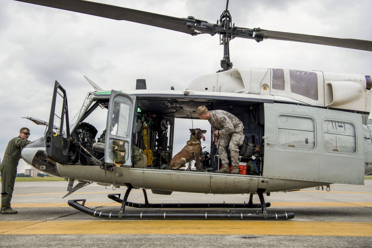 An Air Force helicopter with two crew members and Topa, the military working dog.