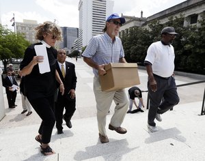 File - Ray Krone, center, who was the 100th inmate exonerated from death row since the death penalty was reinstated, carries a box of petition signatures to be delivered to Gov. Bill Haslam after a protest against the death penalty Tuesday, Aug. 7, 2018, in Nashville, Tenn.