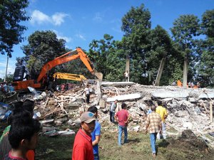 Rescuers use heavy machine to search for survivors under the rubble of a collapsed building after an earthquake in Pidie Jaya, Aceh province, Indonesia