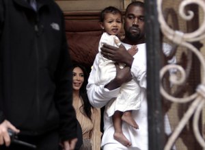 Kim Kardashian, a US reality TV star, and her husband Kanye West holding their daughter North West