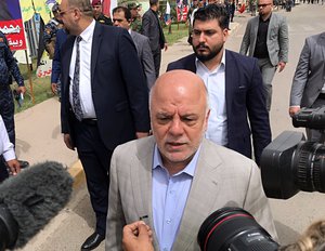 Iraq Prime Minister Haider al-Abadi, center, speaks to reporters after casting his ballot in the country's parliamentary elections in Baghdad, Iraq, Saturday, May 12, 2018.