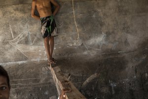 In this Oct. 30, 2016 photo, children play inside a depot used by fishermen to store their nets and repair boats in Punta de Araya, Sucre state, Venezuela.