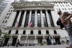 In this Oct. 24, 2017, file photo people pass the New York Stock Exchange