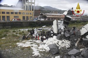 This photo released by the Italian firefighters, cars are seen among the rubble of the collapsed Morandi highway bridge in Genoa, northern Italy, Tuesday, Aug. 14, 2018.