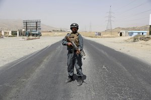 An Afghan Police officer keep watch at a checkpoint on the Ghazni highway, in Maidan Shar, west of Kabul, Afghanistan, Monday, Aug. 13, 2018.