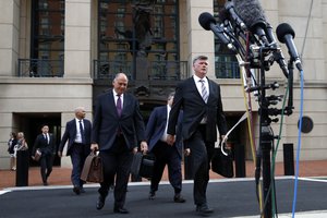 Defense attorney Kevin Downing, right, with members of the defense team for Paul Manafort, approaches the microphones to make a short statement outside of federal court after closing arguments and jury instructions ended in the trial of the former Trump campaign chairman, in Alexandria, Va., Wednesday, Aug. 15, 2018.