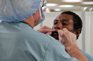 Operation Smile volunteer Dr. Robert Russell, a plastic surgeon from Springfield, Ill., examines a patient before performing reconstructive surgery.