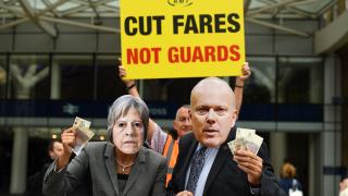 Protesters from the Rail, Maritime and Transport union dressed as Theresa May and Chris Grayling at King's Cross station in London