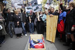 Animal-rights activists protest next to the coffin of a dead dolphin near the Danish Embassy, in Paris, Thursday, Sept. 30, 2010.