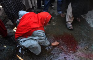 A woman cleans blood from the scene of a shootout in Srinagar March 10, 2011. Two militants belonging to Jaish-e-Mohammad, a Pakistan based militant group, were killed in a shootout in Srinagar on Thursday, police said.