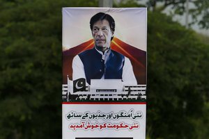 A poster with images of Imran Khan is displayed in the celebration of his government at a highway in Islamabad, Pakistan, Saturday, Aug. 18, 2018.