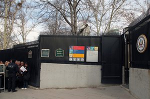 A Turkish police officer stands in front of people waiting for visas near the side entrance of the U. S. embassy