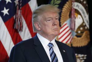 President Donald Trump listens as Treasury Secretary Steve Mnuchin speaks at the Treasury Department in Washington, Friday, April 21, 2017.