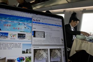 ** HOLD FOR STORY CHINA DRUGS DISPUTE BY ERIKA KINETZ and GILLIAN WONG ** FILE - In this Oct. 26, 2016, file photo, a man drinks tea near a computer screen displaying websites of companies selling carfentanil online on a train leaving Beijing. U.S. assertions that China is the top source of the synthetic opioids that have killed thousands of drug users in the U.S. and Canada are unsubstantiated, Chinese officials told the Associated Press. (AP Photo/Ng Han Guan, File)