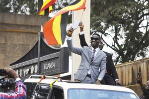 In this photo taken Tuesday, July 11, 2017, Ugandan pop star Kyagulanyi Ssentamu, better known as Bobi Wine, center, gestures to supporters shortly after being sworn in as a member of parliament in Kampala, Uganda