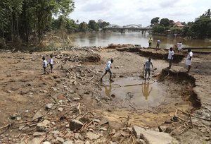 People assess damage caused by floods on the outskirts of Kochi in the southern state of Kerala, India, Wednesday, Aug. 22, 2018.