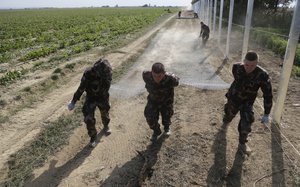 In this Sept. 22, 2015 file photo hungarian soldiers work on a fence that is being built at the border with Croatia, near the village of Beremend, Hungary.