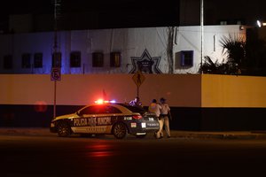 Municipal police stand guard at the end of a block containing the state prosecutor's office, in Cancun, Mexico, Tuesday, Jan. 17, 2017.