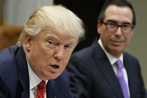 Treasury Secretary Steven Mnuchin listens at right as President Donald Trump speaks during a meeting on the Federal budget, Wednesday, Feb. 22, 2017, in the Roosevelt Room of the White House in Washington.