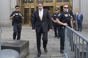 In this Aug. 21, 2018, photo, Michael Cohen, center, leaves federal court in New York.